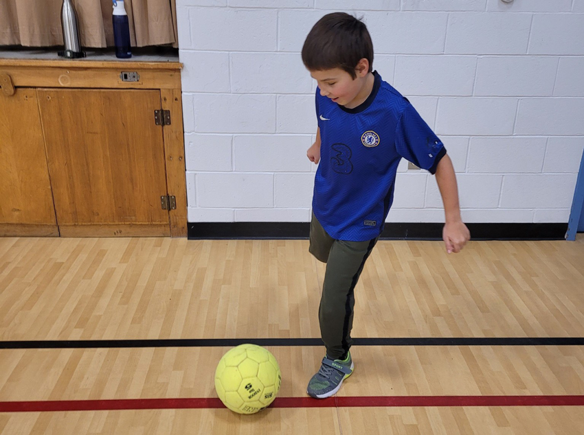 Un élève s'apparaître a frapper la balle de soccer