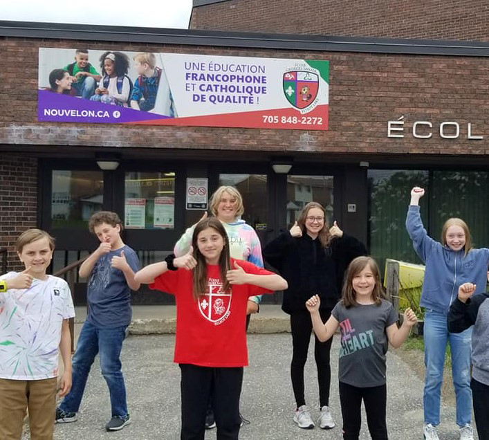 Des élèves heureux devant leur écoles