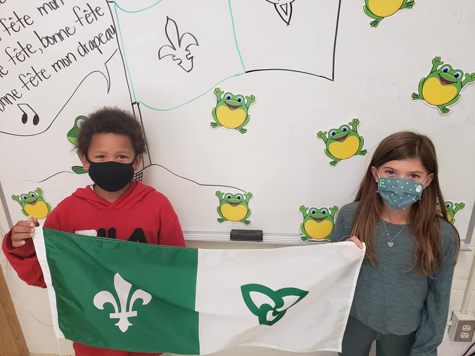 Deux élèves tiennent le drapeau de la francophonie