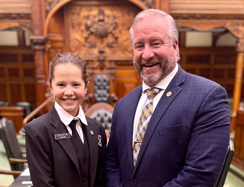 Une petite fille très contente de serré la main du monsieur à coté d'elle