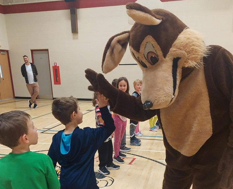 Mascotte de l'école Trillium done un high five au élèves