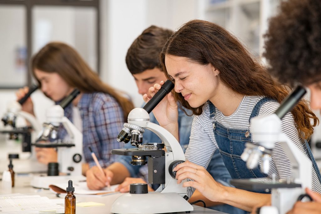 Un groupe d'élève regarde à travers un microscope